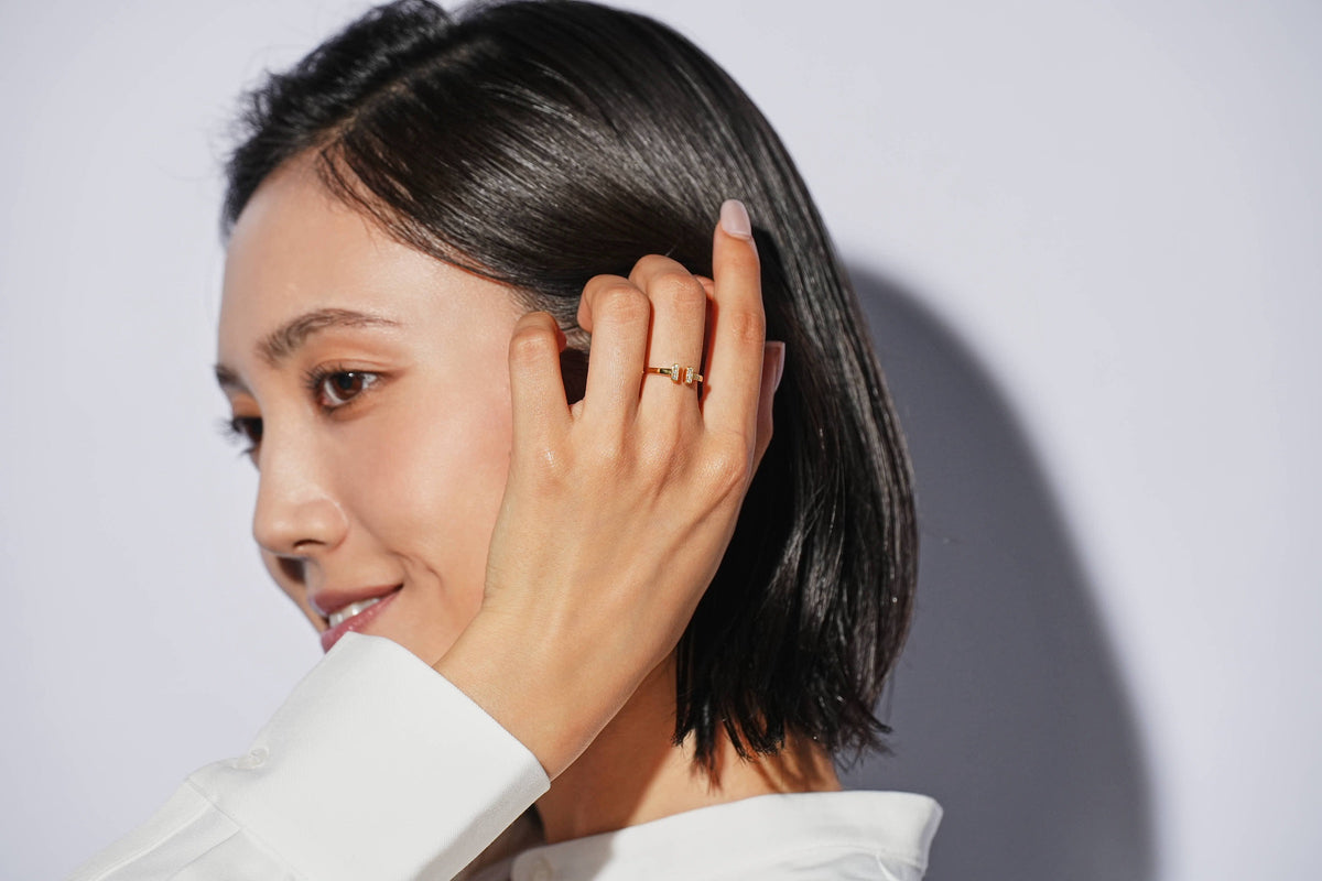 髪に手を添える女性の横顔とリング